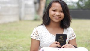 Girl holding Book of Mormon