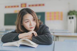 girl with book inside classroom