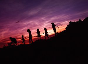 silhouette six children with dog playing