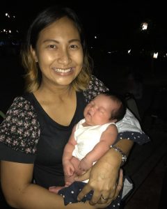 baby in mother's arms at night