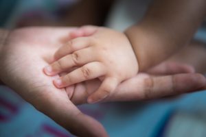 baby hand on mother's hand