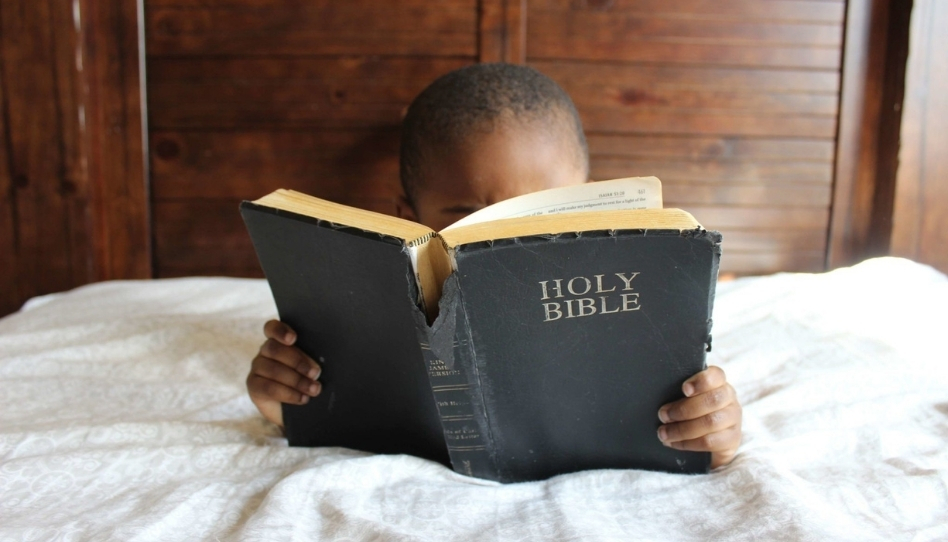 A boy reading a Bible.